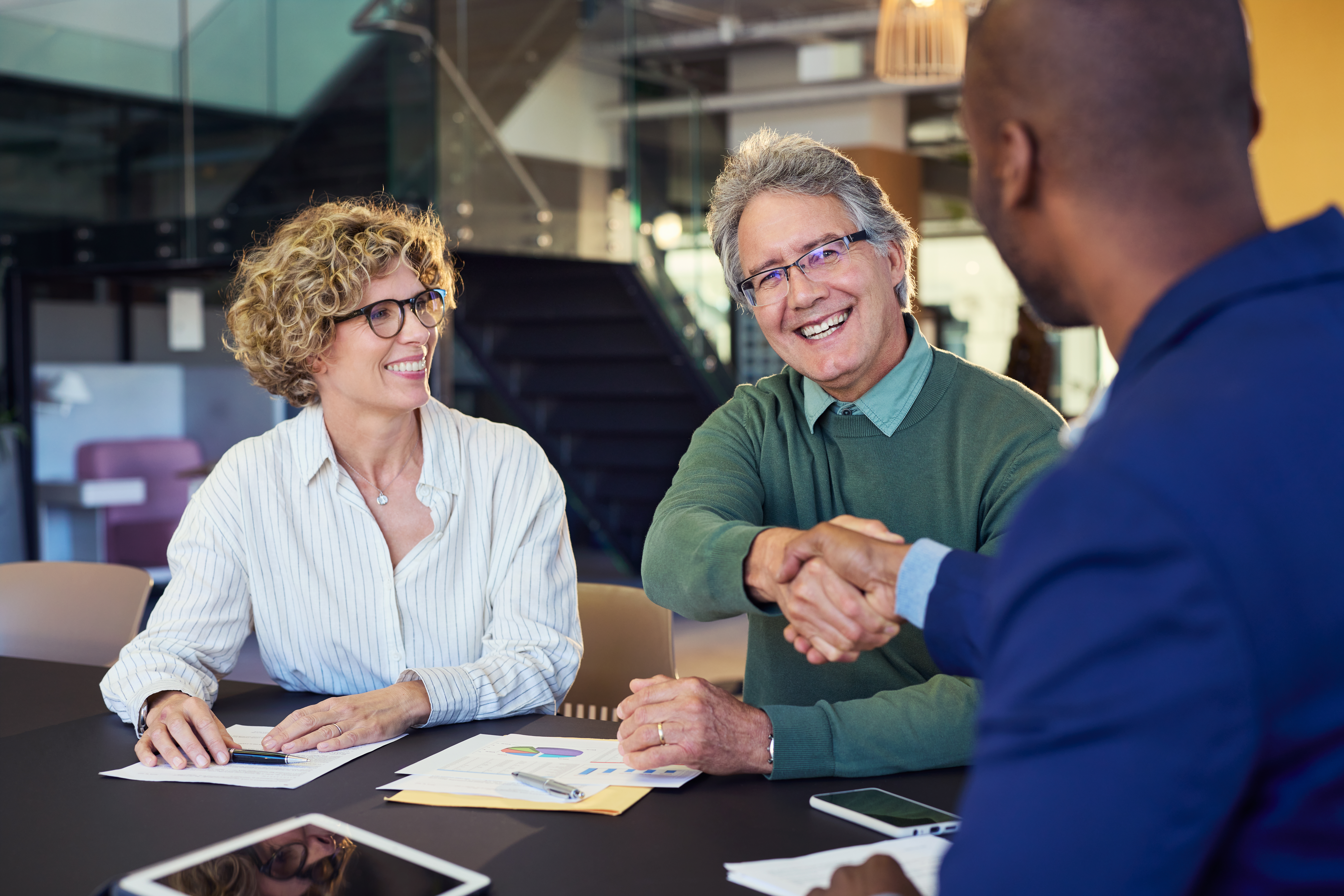 Friendly client meeting with a confident handshake, representing effective customer acquisition strategies.