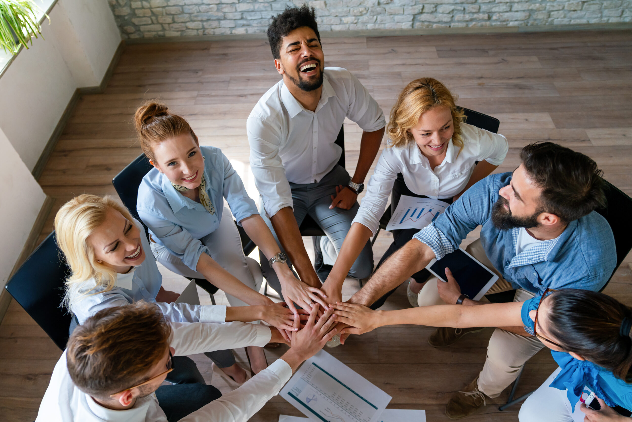 Team members stacking hands together, demonstrating effective team building strategies and strong collaboration.