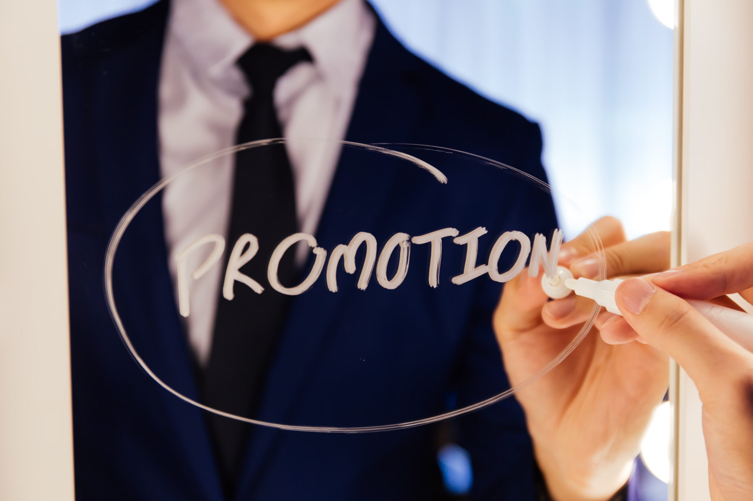 A business professional highlighting brand promotion strategies on a glass board during a business presentation.
